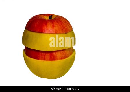 A stack of fresh and ripe red and yellow apple slices with water droplets and leaves on a white background. Stock Photo