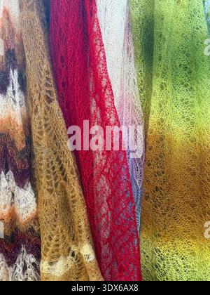 Colorful knitted mohair drapery with lace pattern texture in multicolor tones, vertical folds. Natural woolen background, fashion knitted fabric Stock Photo
