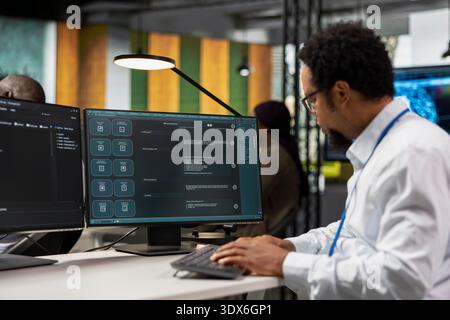 Close up of IT employee in office automating repetitive tasks using AI LLM chatbot assistance. Startup computer scientist uses machine learning large language model assistant on PC Stock Photo
