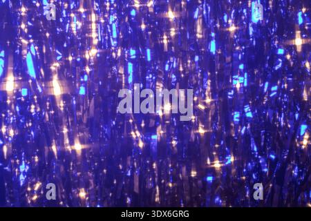 A vibrant abstract background featuring glowing blue and gold colors, with a bokeh effect creating a shimmering glitter texture, perfect for festive o Stock Photo