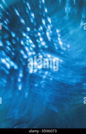 A mesmerizing abstract background featuring a glowing bokeh effect. This image showcases a captivating blend of blue hues, creating a glittering, text Stock Photo
