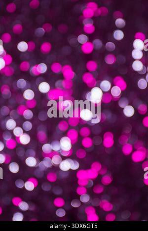 A mesmerizing abstract background featuring glowing pink bokeh effects, creating a shimmering texture of glittering lights. Perfect for festive or art Stock Photo