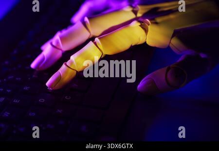 Close-up of a robotic hand typing effortlessly on a computer keyboard under ambient neon lighting. Reflects the integration of artificial intelligence Stock Photo