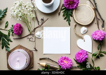 A romantic flatlay for Valentine's Day, featuring a blank notebook surrounded by vibrant purple flowers, a coffee cup, and decorative elements on a ne Stock Photo