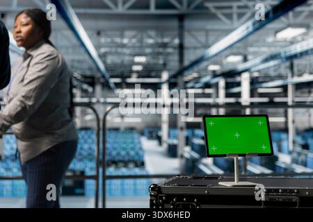 Close up of green screen tablet in front of data center workers developing disaster recovery plans for minimal downtime. Server room colleagues using mockup device to enhance operational effectiveness Stock Photo