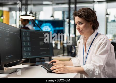 Computer scientist running AI large language model chatbot on PC in startup workspace. IT professional using artificial intelligence neural network LLM coding platform on computer Stock Photo