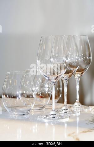 A refined setting featuring empty wine and water glasses arranged on a polished marble table in a gourmet restaurant, highlighting sophistication and Stock Photo