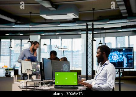 Engineer in office using AI automation scripts on isolated screen laptop to reduce repetitive coding tasks. IT professional using artificial intelligence technology on mockup notebook Stock Photo