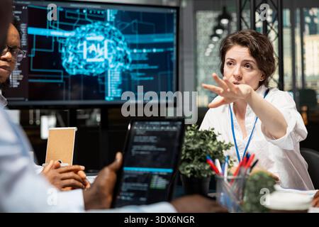 Data scientists in artificial intelligence startup office brainstorming, building scalable solutions for businesses. Coworkers doing meeting to discuss deep learning tech implementation in office Stock Photo