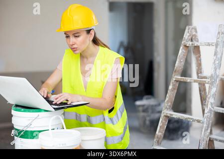 Woman architect using laptop at renovating apartment Stock Photo