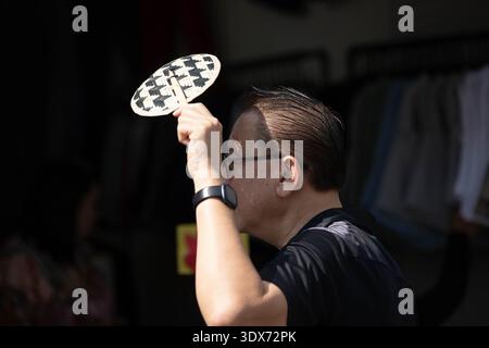 BANGKOK, THAILAND-FEB 1, 2026: Senior man shopping in market, Thai weekend market lifestyle, thinning hair bald head, side profile, Chatuchak Market. Stock Photo