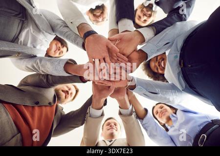 Close up top view photo of diverse business people putting their arms together in stack. Stock Photo