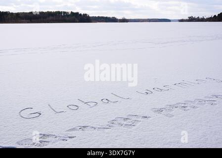 Written GLOBAL WARMING on snow background message ice outdoor on ground in winter. Writing text sign drawing on field in frozen background. Weather changing cold season has arrived environment protection crisis heatwaves climate anxiety. Mockup Copy space for text Creative art and texture  Stock Photo