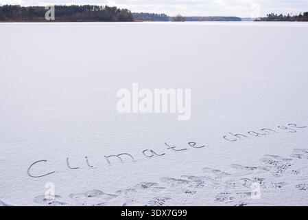 Written CLIMATE CHANGE on snow background message ice outdoor on ground in winter. Writing text sign drawing on field in frozen background. Weather changing cold season has arrived environment protection crisis heatwaves climate anxiety. Mockup Copy space for text Creative art and texture  Stock Photo