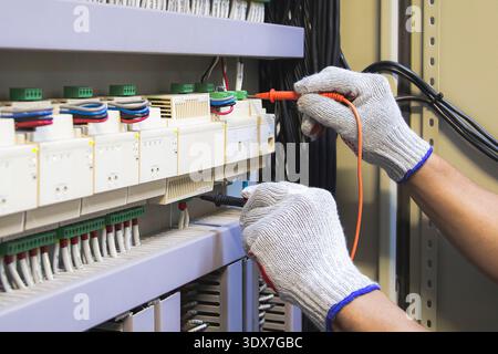 Technicians use multimeter to test or diagnose electrical control devices. Stock Photo