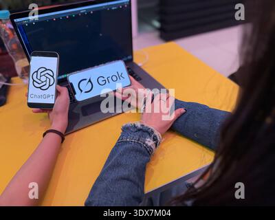 ChatGPT and Grok AI logos displayed on smartphone screens. This editorial image illustrates the competition between OpenAI and xAI technology in 2026. Stock Photo
