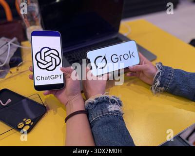 ChatGPT and Grok AI logos displayed on smartphone screens. This editorial image illustrates the competition between OpenAI and xAI technology in 2026. Stock Photo