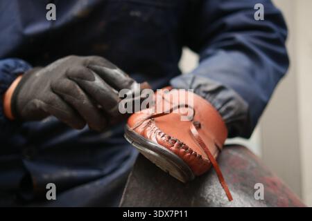 Crafting leather shoes in a workshop during the day Stock Photo