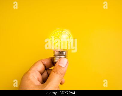 Mental health awareness concept with glowing brain inside light bulb in hand. Mindset development, brain power, emotional wellbeing and positive think Stock Photo