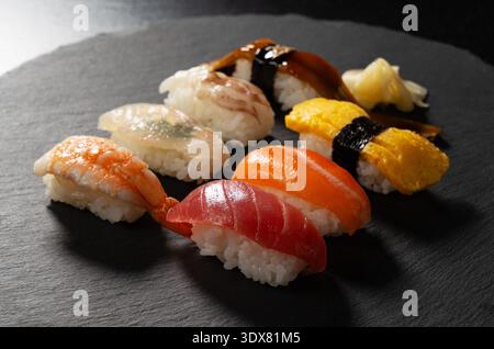 Assorted traditional Japanese nigiri sushi set on a dark slate plate Stock Photo