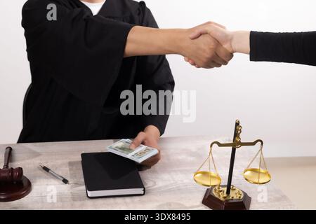 Handshake between two people over a wooden desk in office Stock Photo