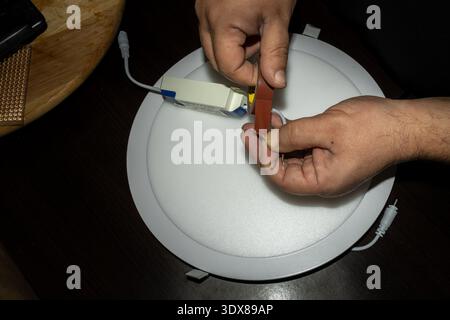 repairing led ceiling light with electrical tools Stock Photo
