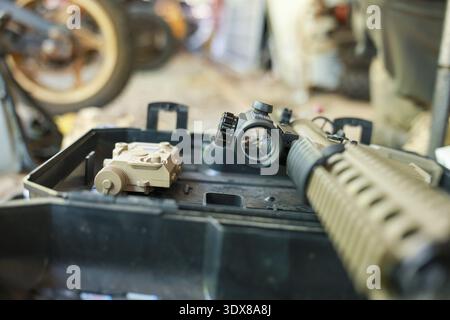 Close up view of tactical rifle red dot sight, laser module, and weapon. This focused image on firearm accessories creates serious and preparatory mil Stock Photo