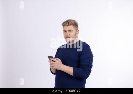Young man using smartphone with a serious look Stock Photo