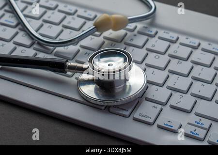 Stethoscope on a white keyboard. Computer troubleshooting, PC diagnostics, IT system health, and technical repair services concept. Stock Photo