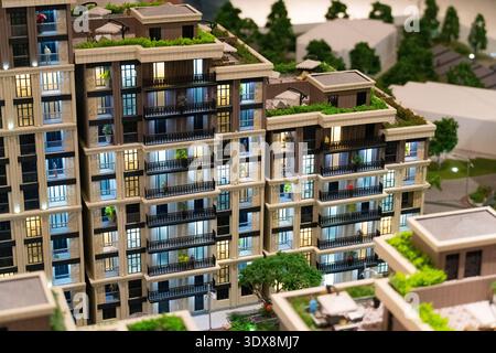 Detailed scale model of modern apartment building with balconies and rooftop terraces. Real estate development and urban planning concept Stock Photo
