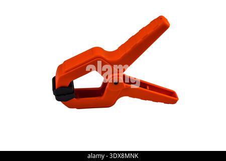 Large orange clip with a spring to hold small objects in place.Auxiliary equipment of the photographer. Stock Photo