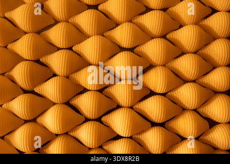 Abstract texture of golden metallic cones in a repeating pattern Stock Photo
