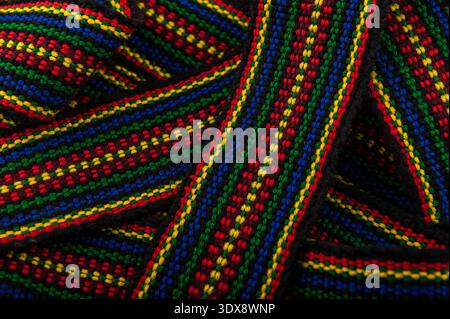 A traditional Ukrainian belt woven from woolen threads.A bright element of folk costume. The belt is on a white background. Stock Photo