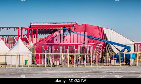 30 November 2025, Doha, Qatar: Construction workers using a cherry picker to set up a massive ceremonial tent for an event in a middle eastern style Stock Photo