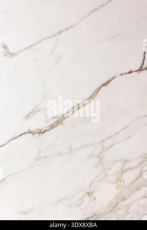 The image shows a close-up of a white marble surface with natural beige and gray veining. The organic lines create an elegant and minimal pattern, hig Stock Photo