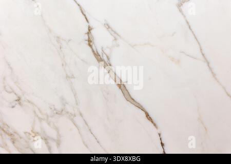 The image shows a close-up of a white marble surface with natural beige and gray veining. The organic lines create an elegant and minimal pattern, hig Stock Photo