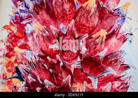 1 December 2025, Doha, Qatar: Vibrant red abstract glass sculpture featuring intricate floral forms, showcasing a beautiful artistic arrangement Stock Photo