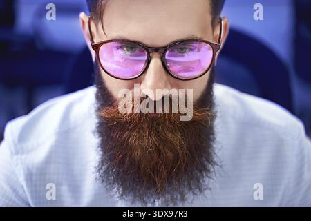 Senior developer working on computer in IT office, sitting at desk and coding, working on a project in software development company or startup. High q Stock Photo