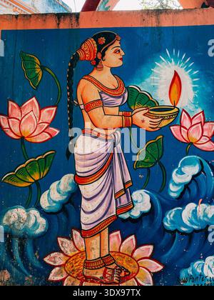 Street mural of a traditional Indian woman holding a diya lamp on a lotus in Varanasie Stock Photo
