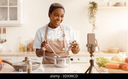 Cooking Tutorial in a Modern Kitchen With a Woman Preparing Food and Interacting With a Camera Stock Photo