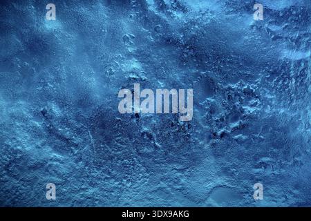 Deep blue frozen ice surface showing detailed rough textures and abstract background, representing cold winter wilderness environment Stock Photo