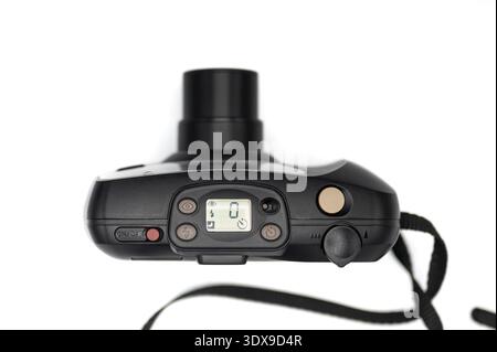 Top view of a vintage black 35mm compact film camera with its zoom lens fully extended, featuring an active LCD control panel and buttons, isolated on Stock Photo