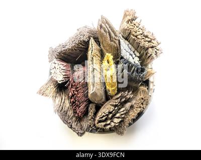 Bunch of used and dried paint brushes in paint bucket shot from above Stock Photo
