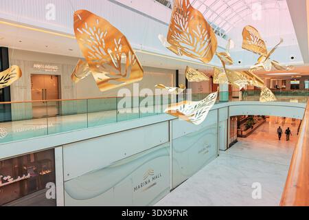5 December 2025, Abu Dhabi, UAE: Marina Mall featuring a large luxury shopping center interior with a unique golden leaves art installation Stock Photo