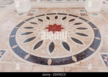 5 December 2025, Abu Dhabi, UAE: Islamic star pattern decorating an outdoor marble mosaic floor Stock Photo