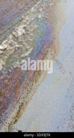 Oil spilled on melting snow. Stock Photo