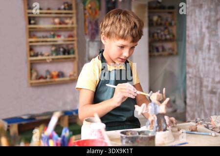 Kids molded from clay at pottery class. || Model released Stock Photo
