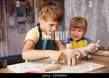 Kids molded from clay at pottery class. || Model released Stock Photo