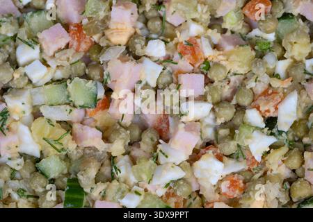 Refreshing grilled meal accompaniment with olives. Chilled olive salad featuring smooth sauce and crunchy peas and cucumbers as perfect grill compleme Stock Photo