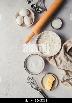 Top view of bowls of baking ingredients and tools on light background. Stock Photo